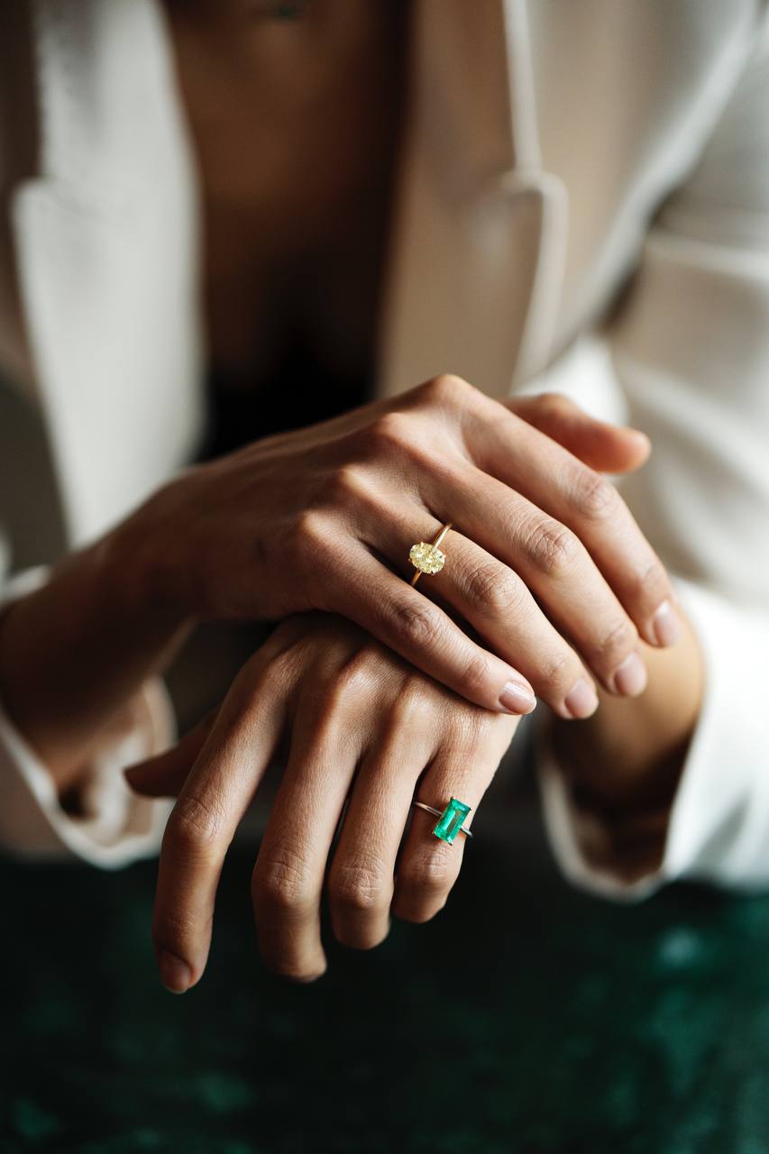 a ring with a green gemstone and a ring with a yellow gemstone