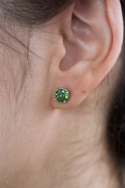 a stud with a green gemstone in the ear