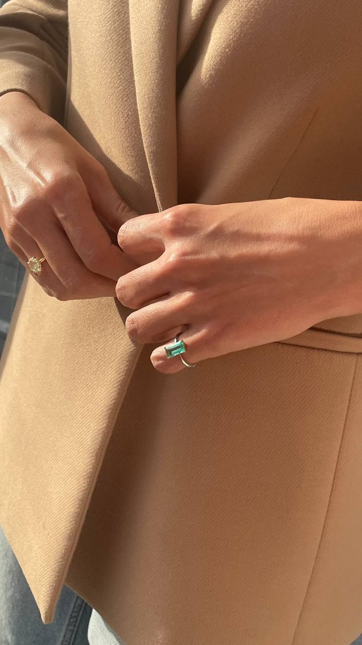 a ring with a green gemstone and a ring with a yellow gemstone